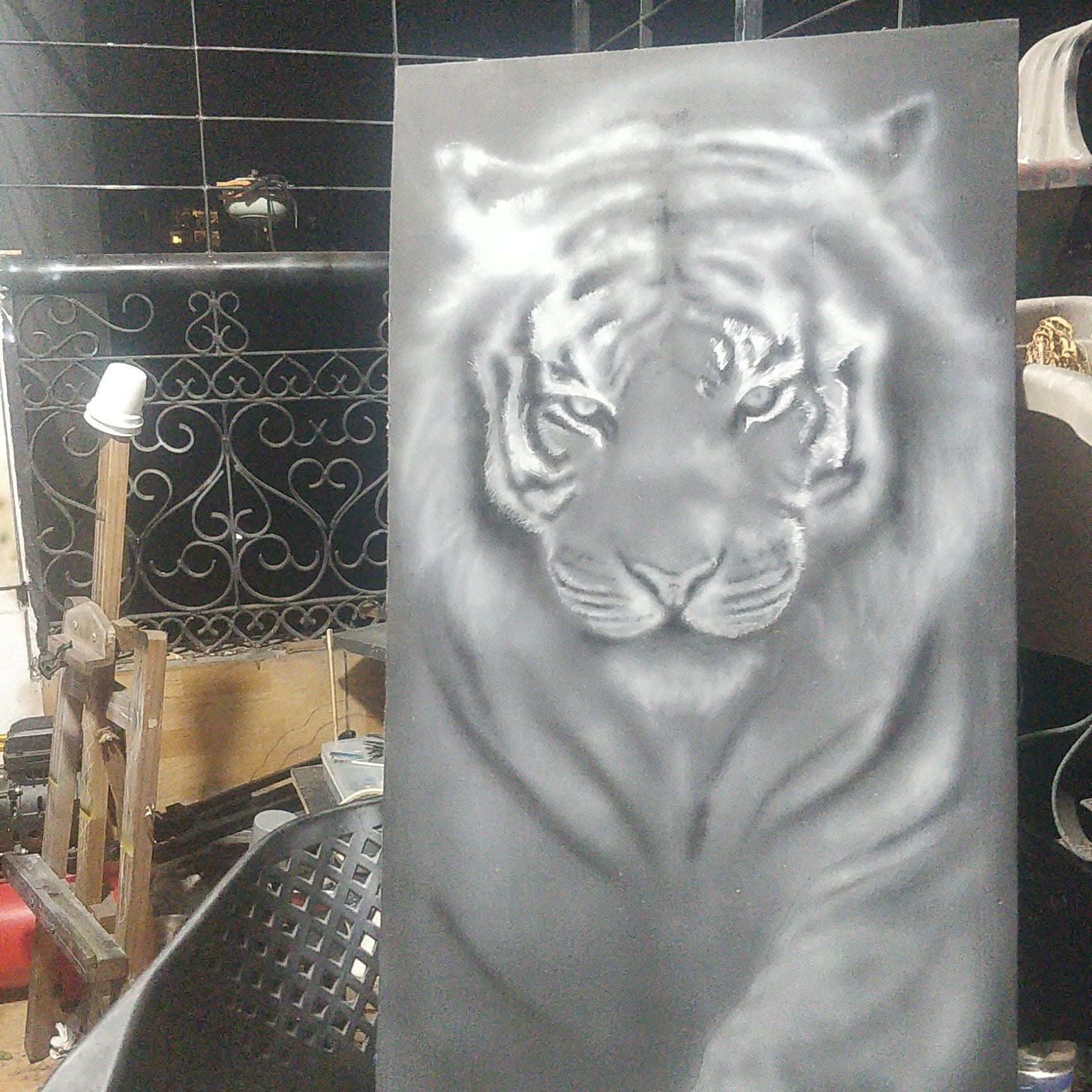 Freehand airbrushed animal portrait in progress on a wooden panel.